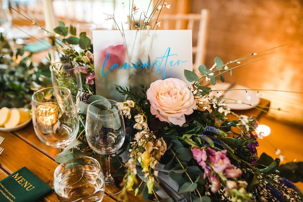 pink and green floral decor for table place names at a weekend wedding