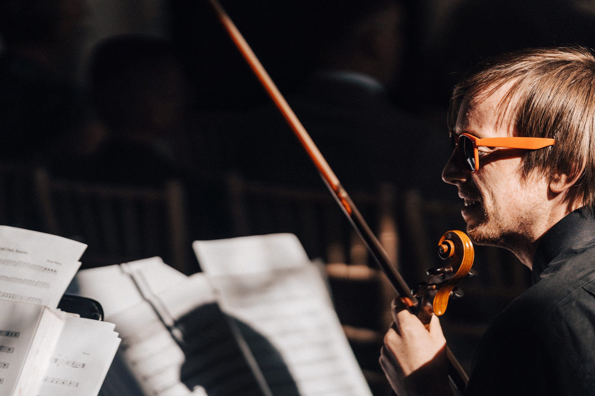 man in sunglasses playing strings at autumn wedding ceremony at elmore court in gloucestershire countryside