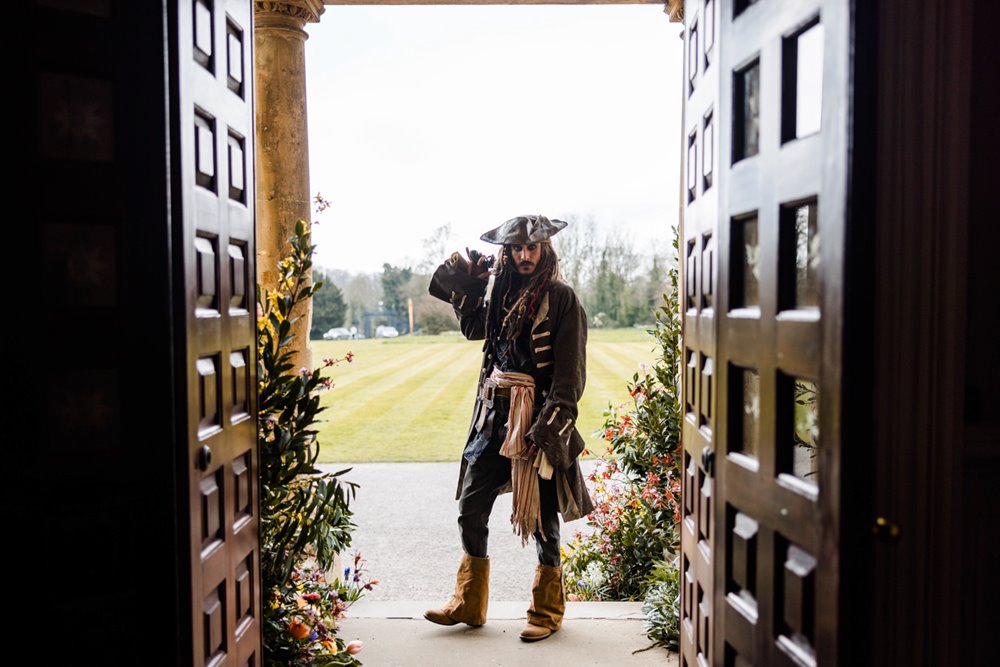 Pirates of the caribbean Jack Sparrow Johnny Depp lookalike  standing in the doorway of Elmore Court with green grassy lawn behind