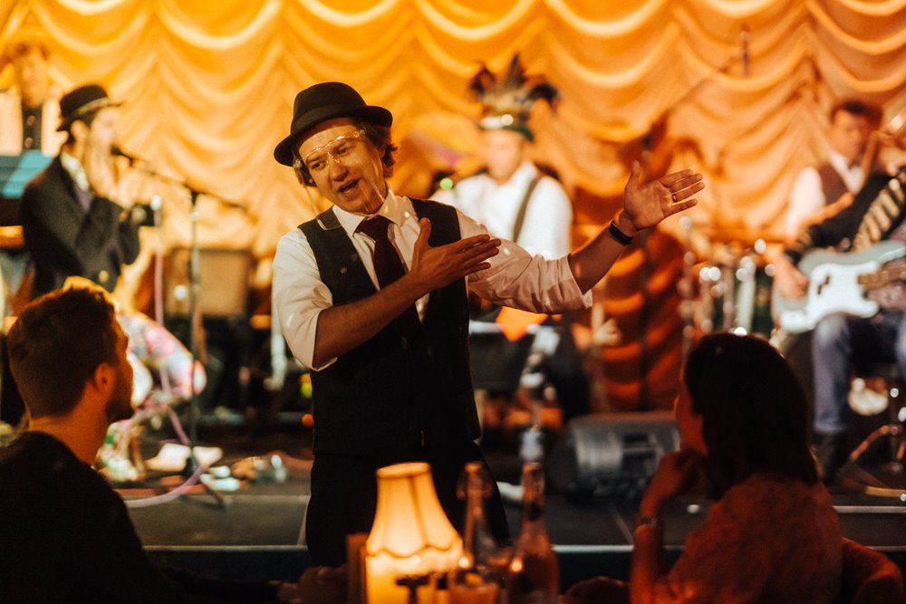 Live close up table magic from award winning magician Darren Campbell, behind him the curious little big band takes the stage