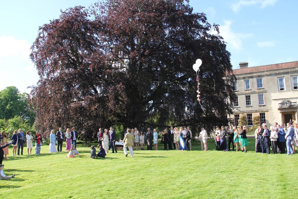 Outdoor druid wedding ceremony with ritual release of balloons at the front of Elmore Court