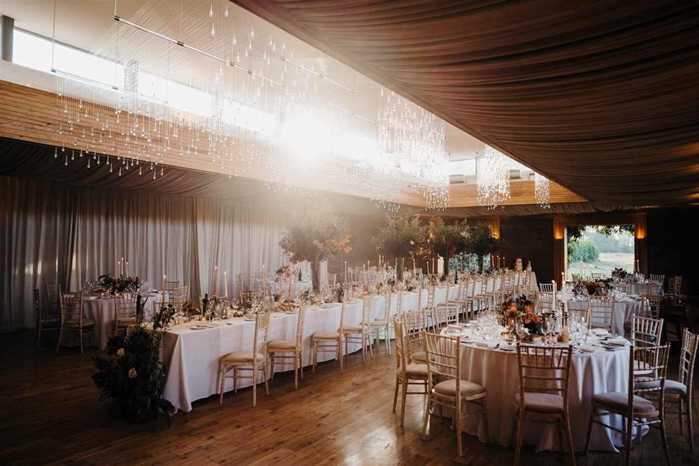 Beautiful autumnal wedding reception with sun burst light in eco build Gillyflower at elmore court