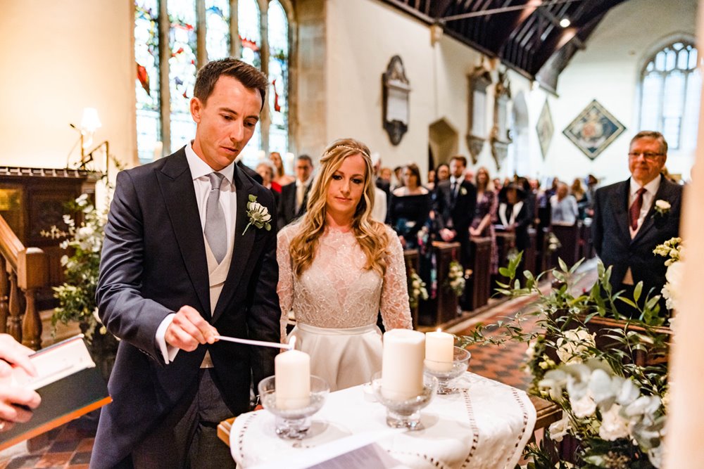 Couple light candles as part of their church wedding service 