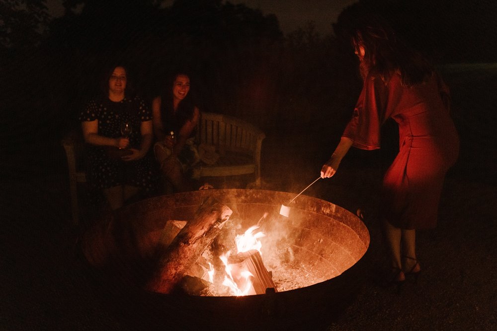 guests enjoying a fire pit and marshmallows at an Elmore Court wedding