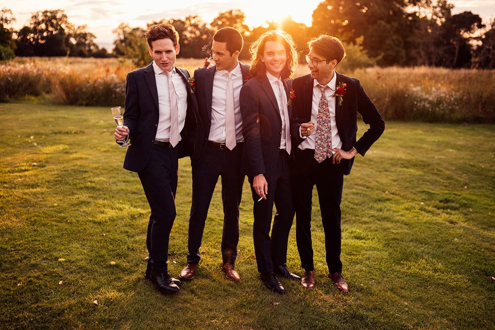 stylish groomsmen in the sunset grounds at wild wedding venue elmore court