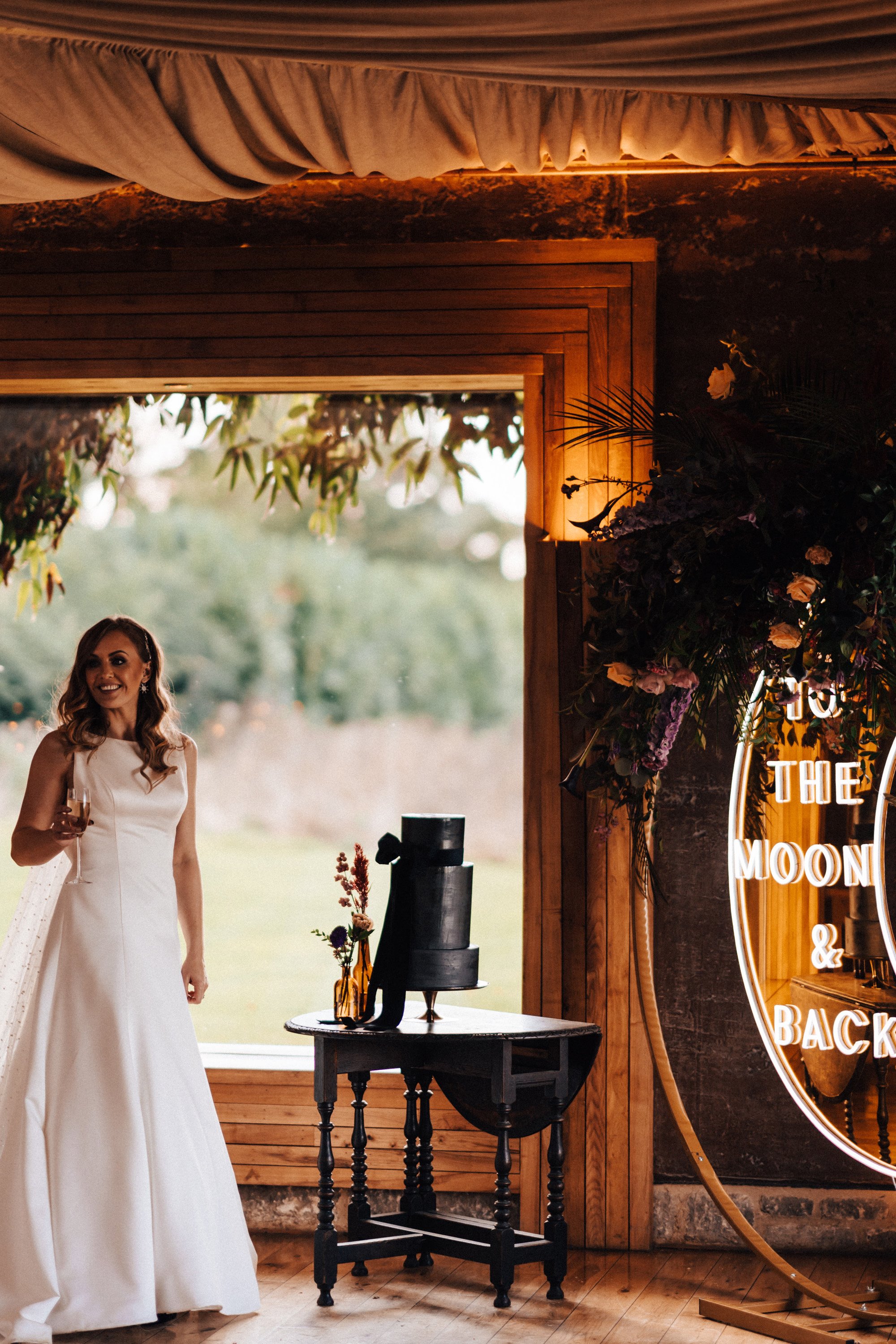 bride creates a black wedding cake herself for her witchy wedding in october with celestial details