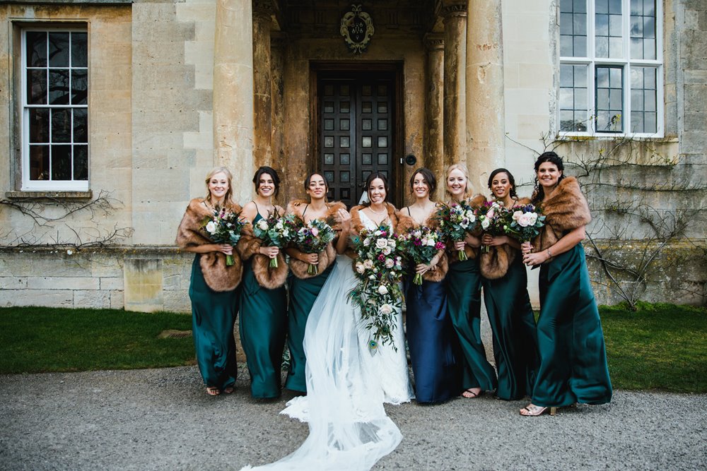 Big bridal party of 7 bridesmaids pose outside wedding venue with accommodation