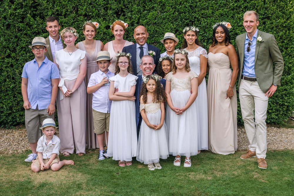 Two grooms pose with their wedding party