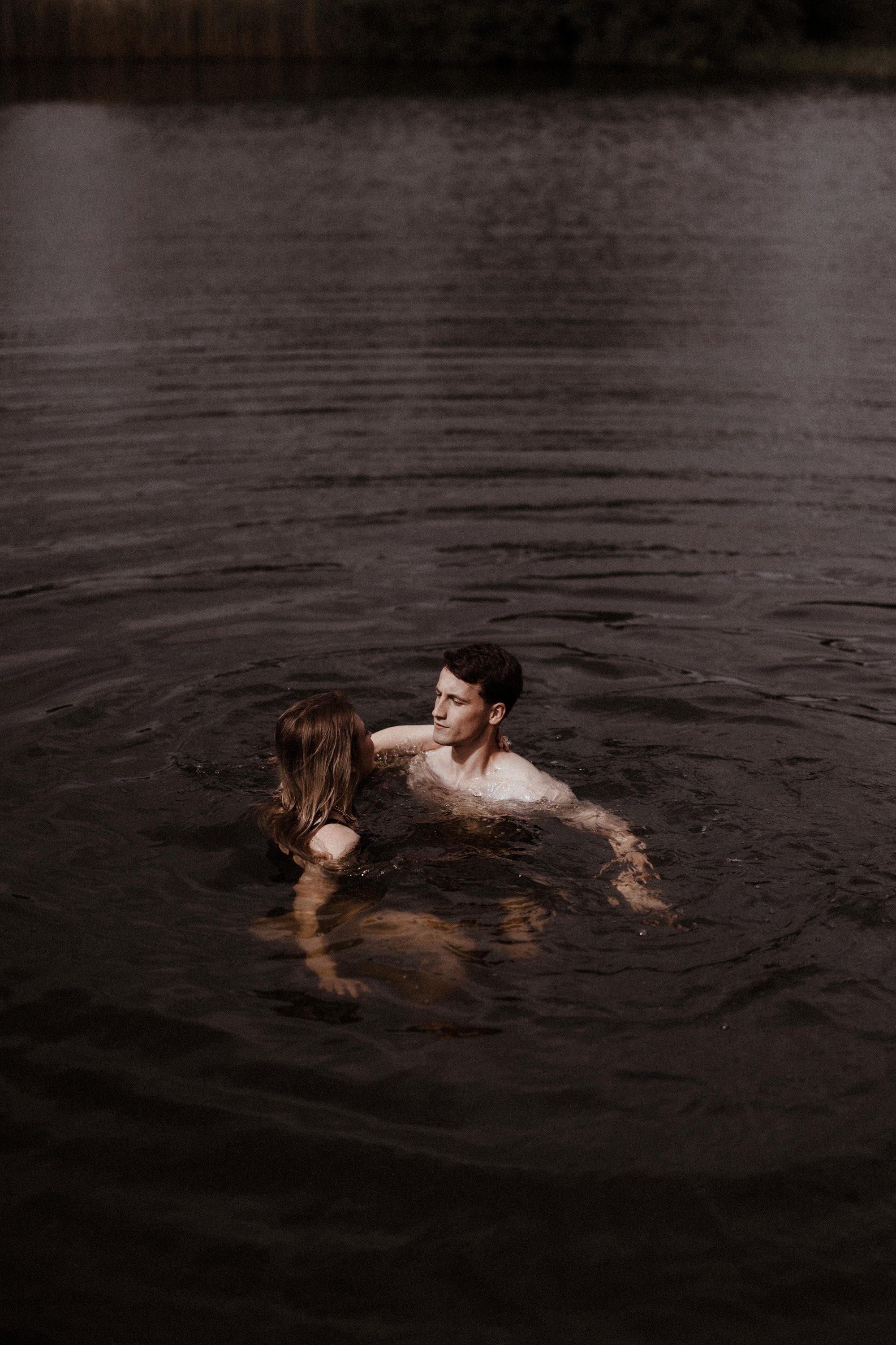 Wild bride and groom swimming in spring fed lake on rewilding land at eco wedding venue elmore court