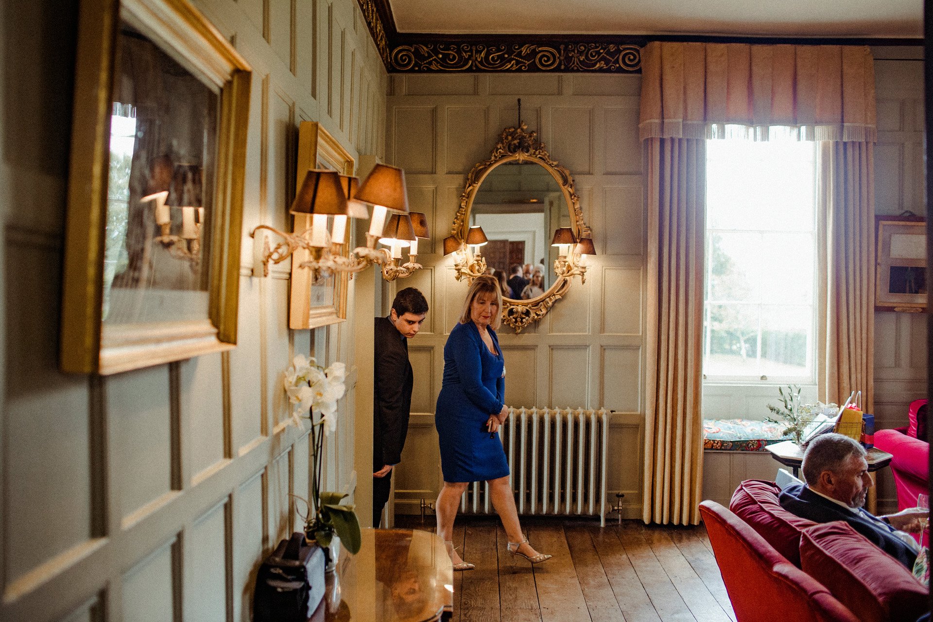 Guests walking into the beautiful wood panelled drawing room at grade 2 listed mansion wedding venue