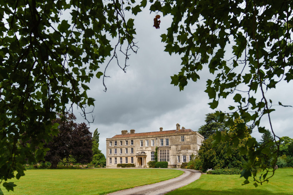 historic house elmore court framed by leaves in the cotswolds
