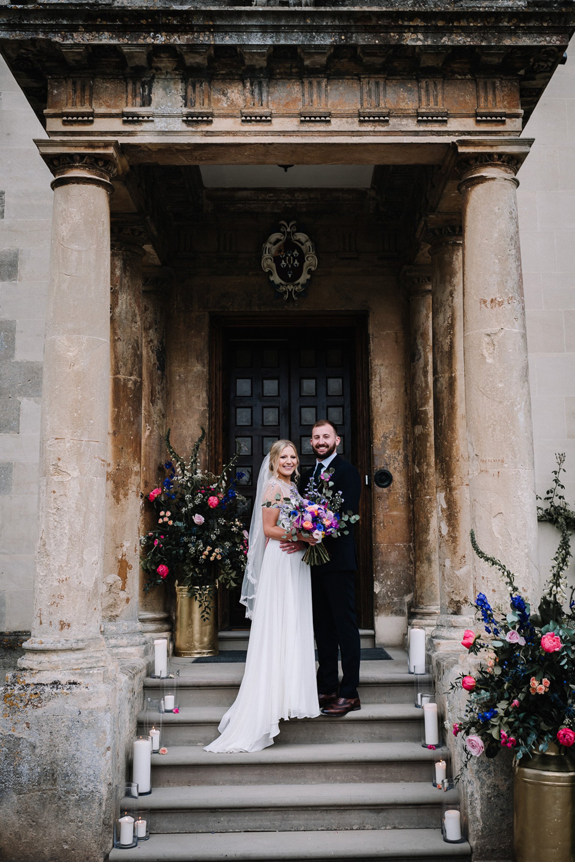 Couple getting wed outdoors under porch with bright flowers as a micro wedding idea