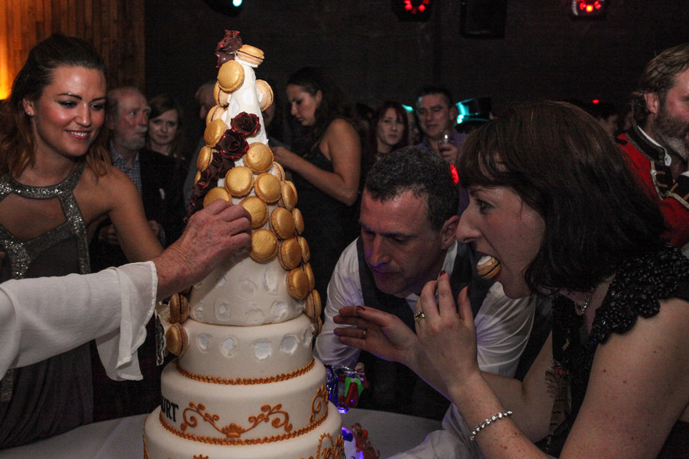 Leesa and Anselm Guise eat macaroons off the tower cake at the elmore court launch party in 2013