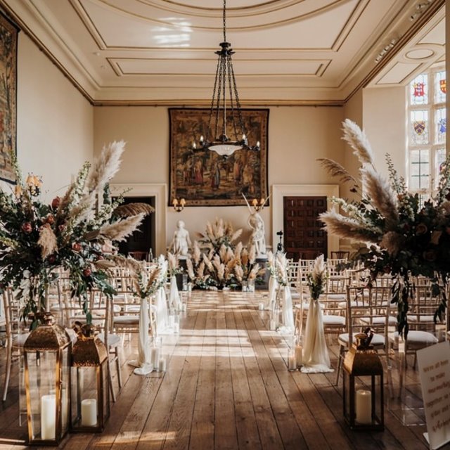 Elegant stately home hall wedding venue with beautiful pampas grass styling down the aisles for a ceremony 