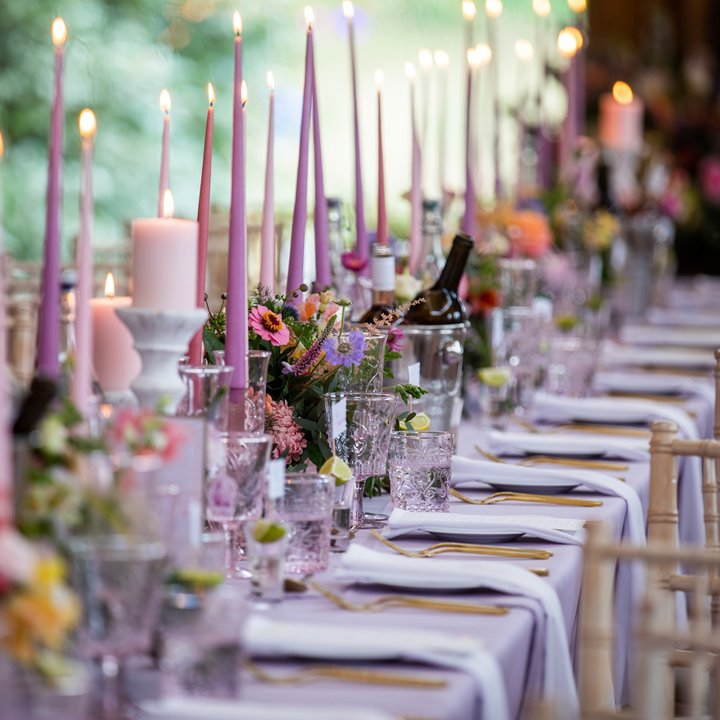 Lilac candles decorate a stunning table set at a wedding in Elmore Courts party room, the Gillyflower. 