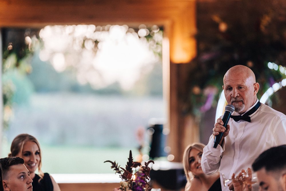 autumn wedding speeches with black wedding cake and crescent moon sign at reception