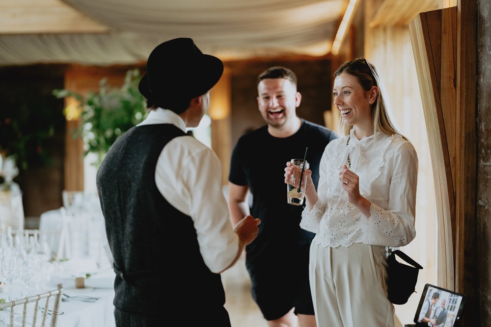 Wedding magician Darren Campbell showing off his tricks to amazed guests at wedding fair at elmore court