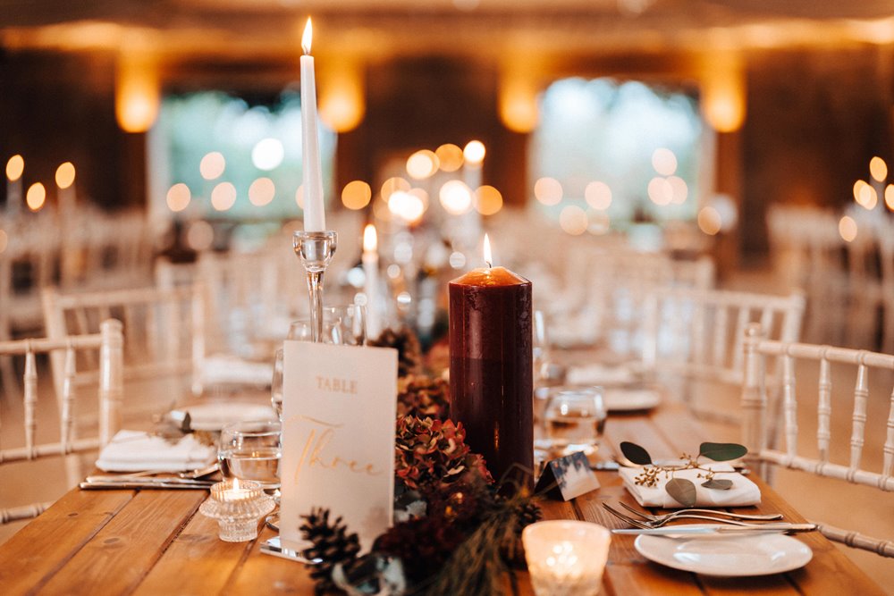 red candles and christmas wedding decor on tables for a magical winter wedding reception in the uk