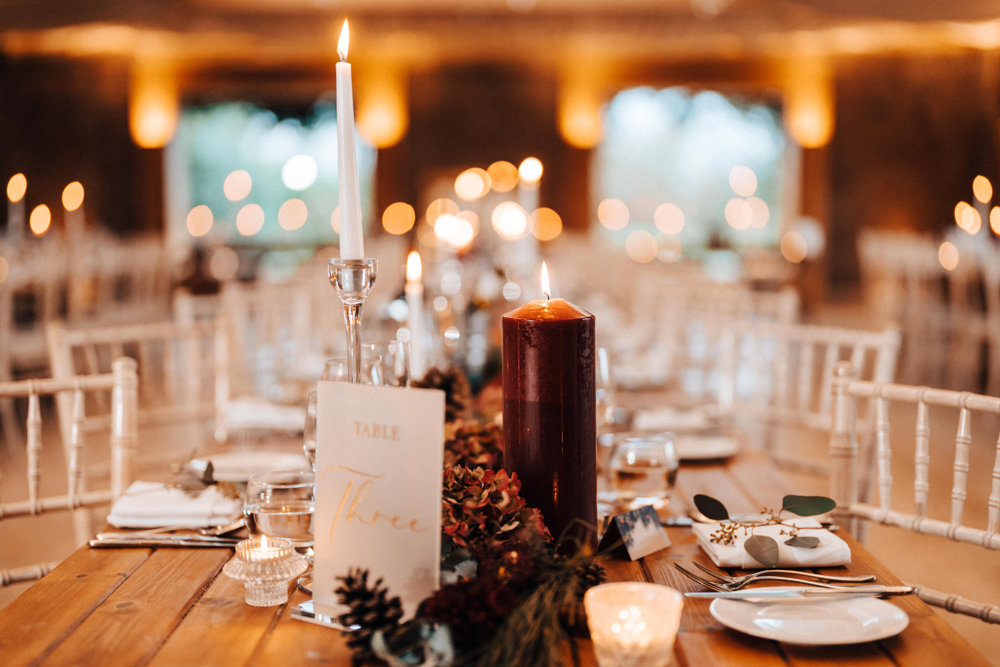 red candles and christmas wedding decor on tables for a magical winter wedding reception in the uk