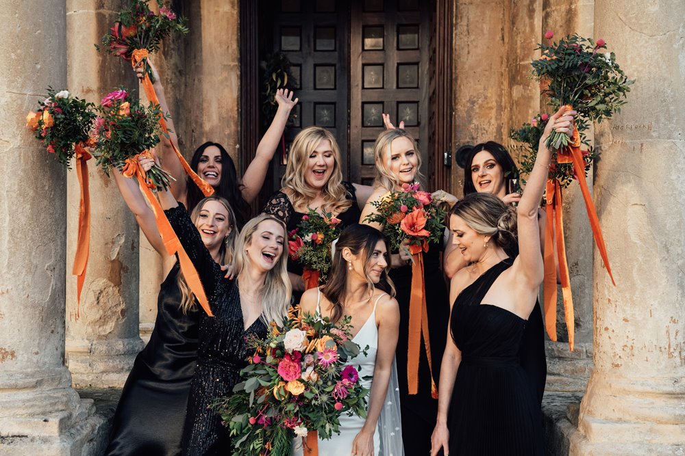 black bridesmaids dresses and bright bouquets for this cool christmas wedding at a stately home in the cotswolds
