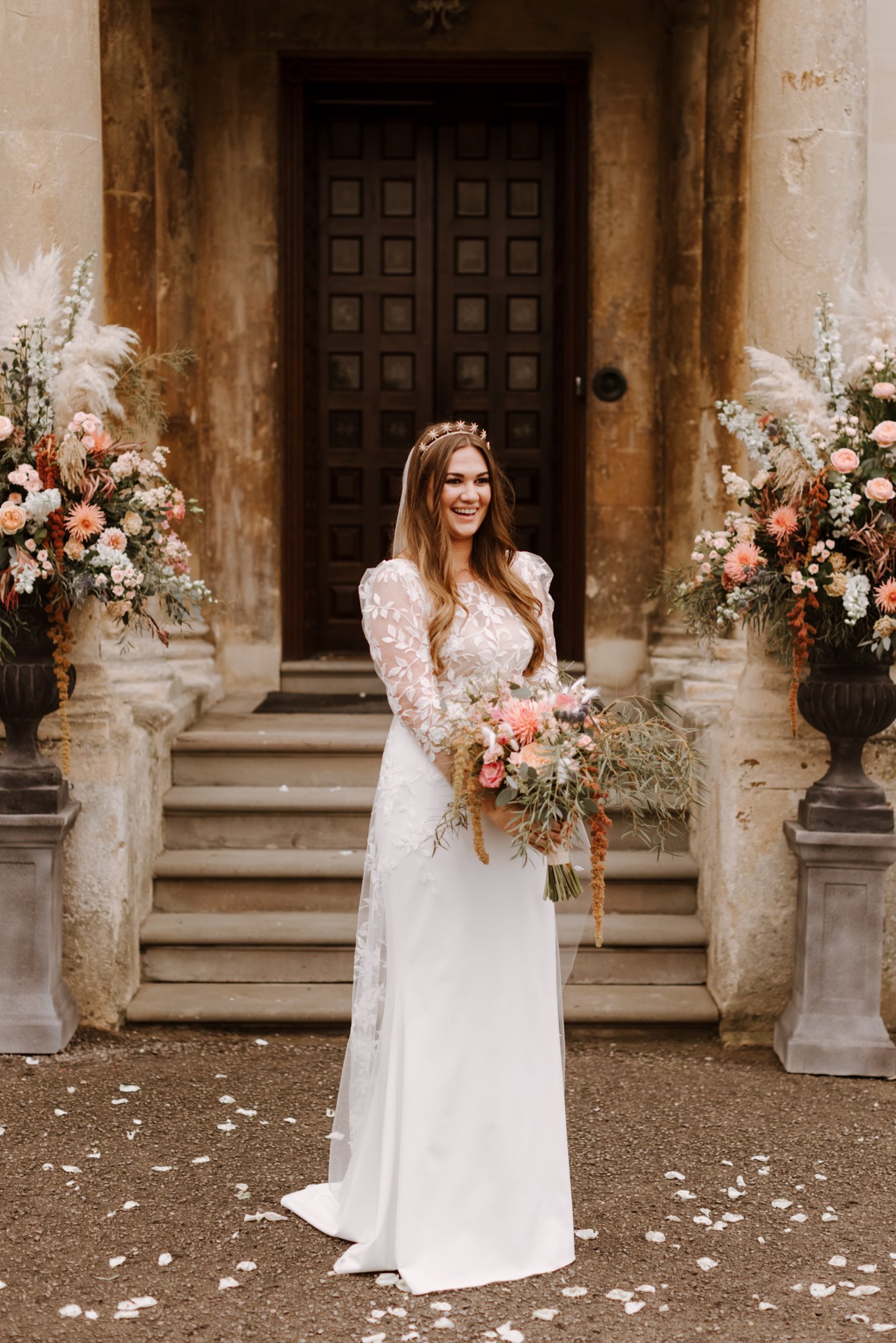 Boho bride in design lace dress and crown at her september wedding day at stately home elmore court