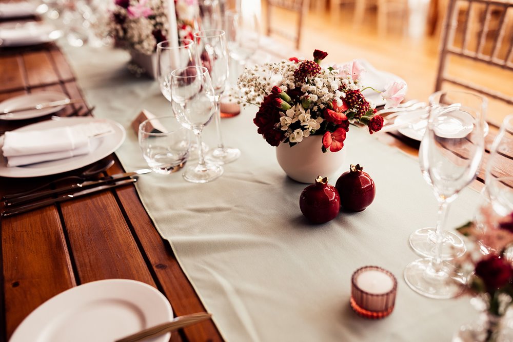 pink and red wedding decor on tables at reception