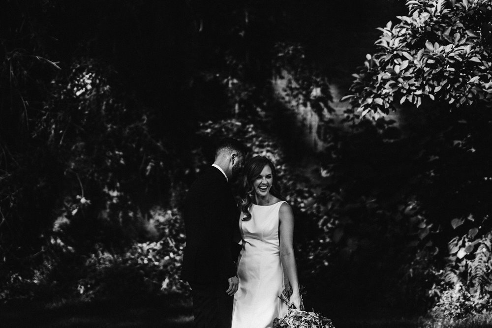 moody photo of beautiful bride and groom posing in the walled garden at their autumnal wedding at stately home in the cotswolds