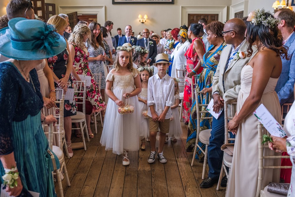 Flower girls and page boys lead grooms into same sex marriage ceremony room