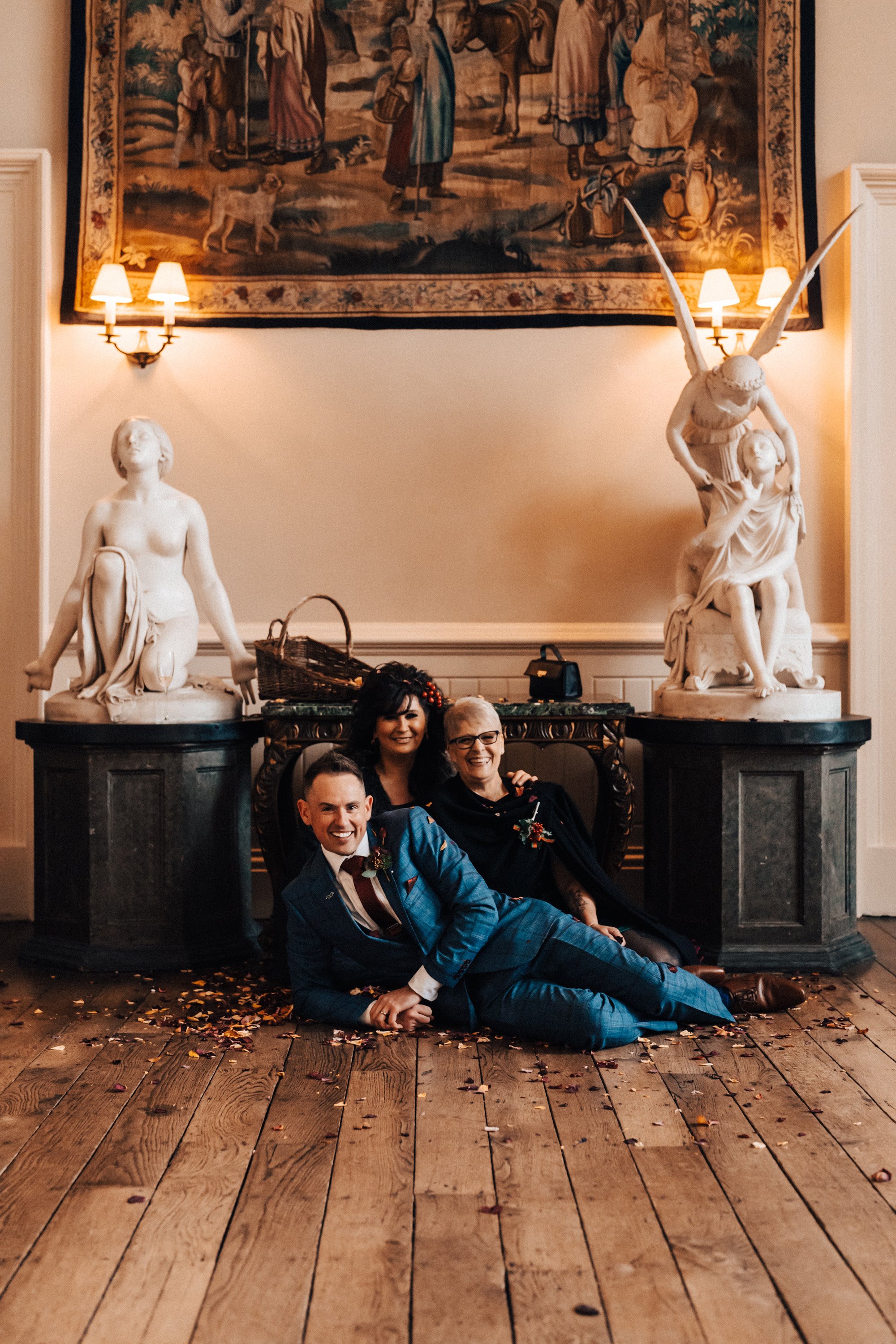 fun wedding photo with groom posing with mums and confetti