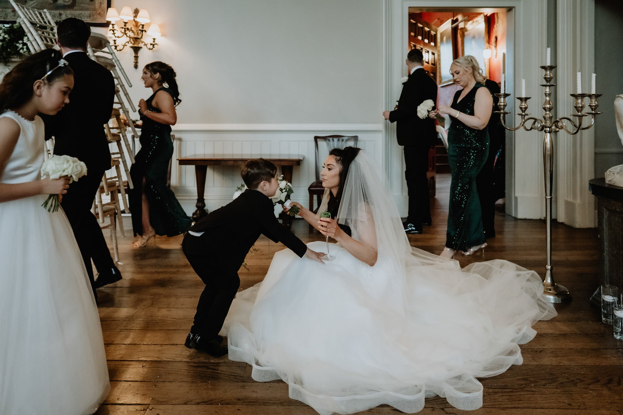 Bride kneeling down to hug a young family member at her wedding