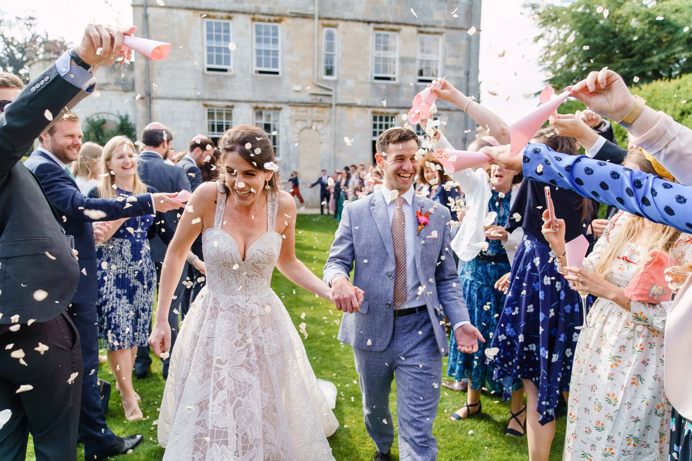 Bride and groom confetti shot on the lawn of stately home elmore court