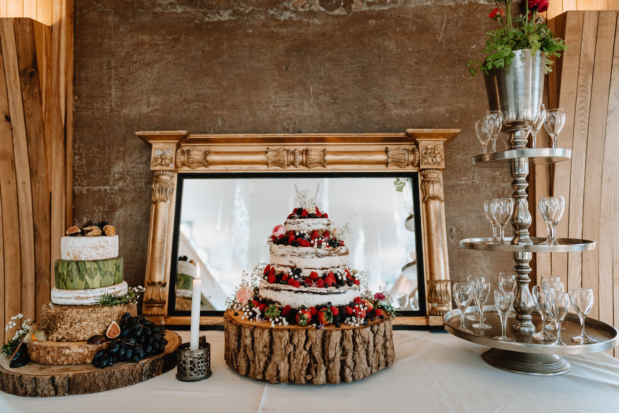 Wedding cakes, cheeses and tower of champagne glasses at a wedding reception int he Gillyflower at Elmore Court