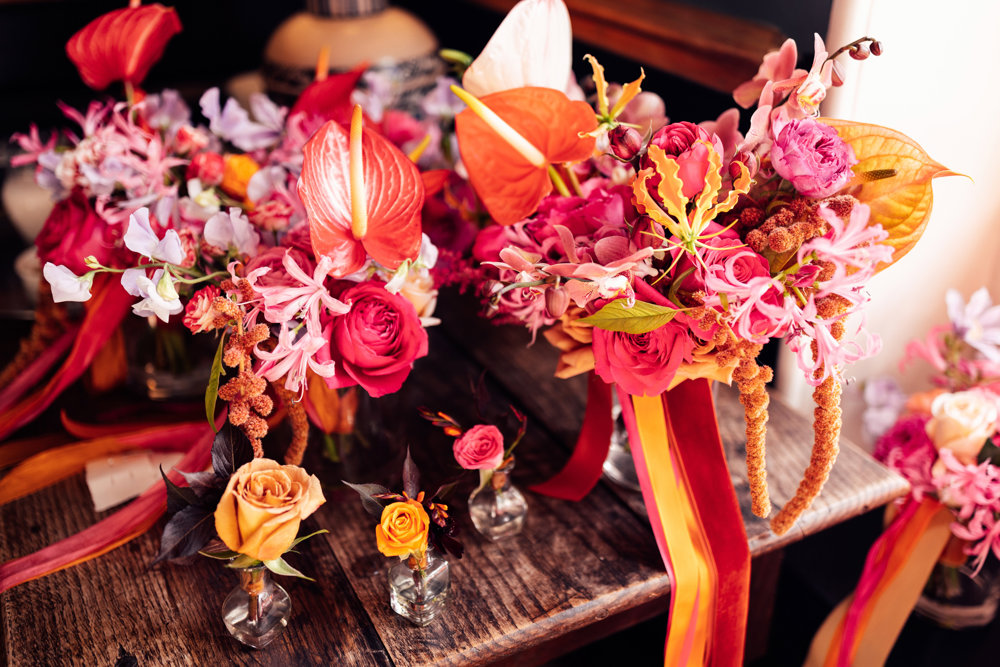 Bright colourful wedding flowers in pink red and orange theme for a fun wedding at elmore court